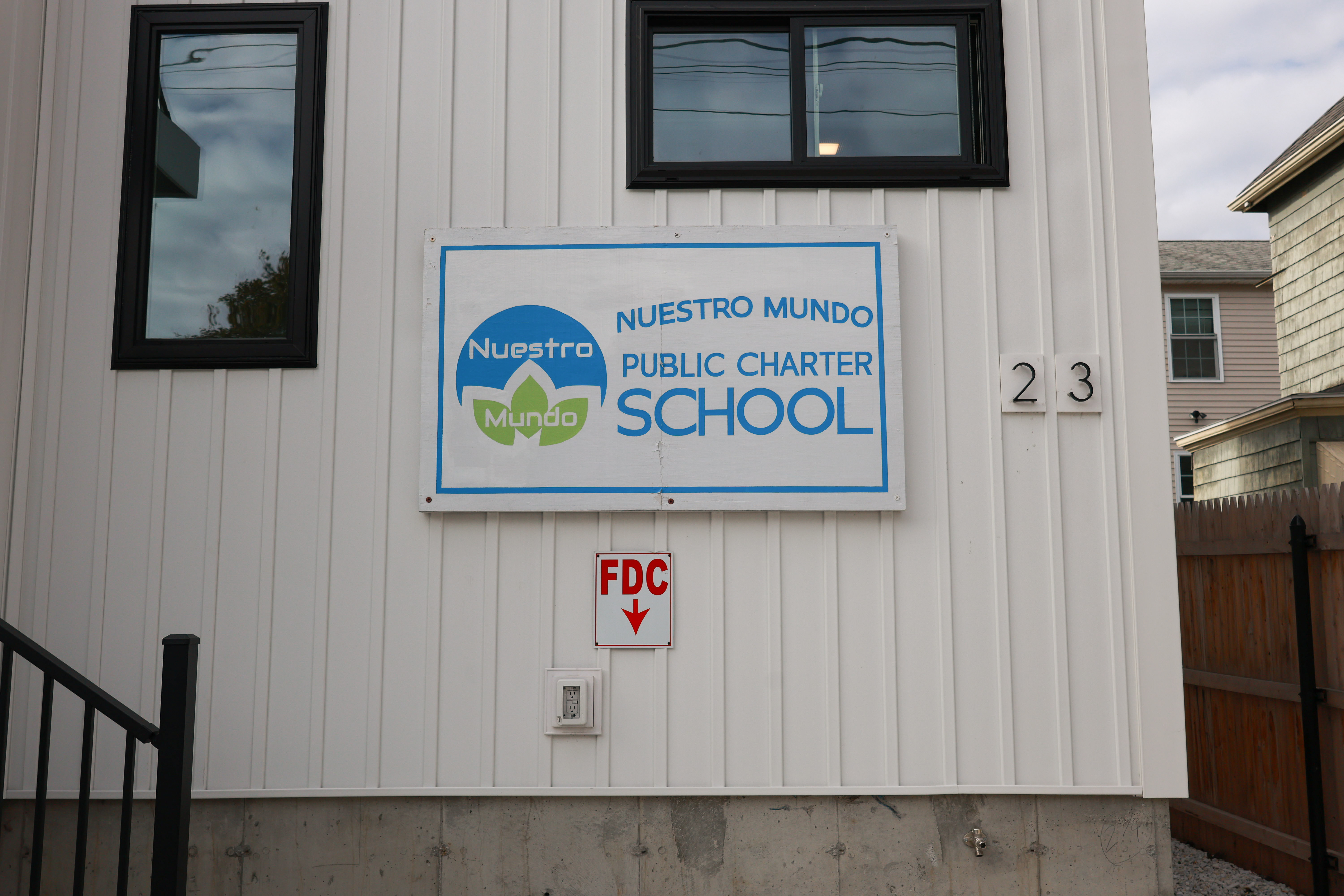 A blue and green 'Nuestro Mundo' sign on the side of a white building.